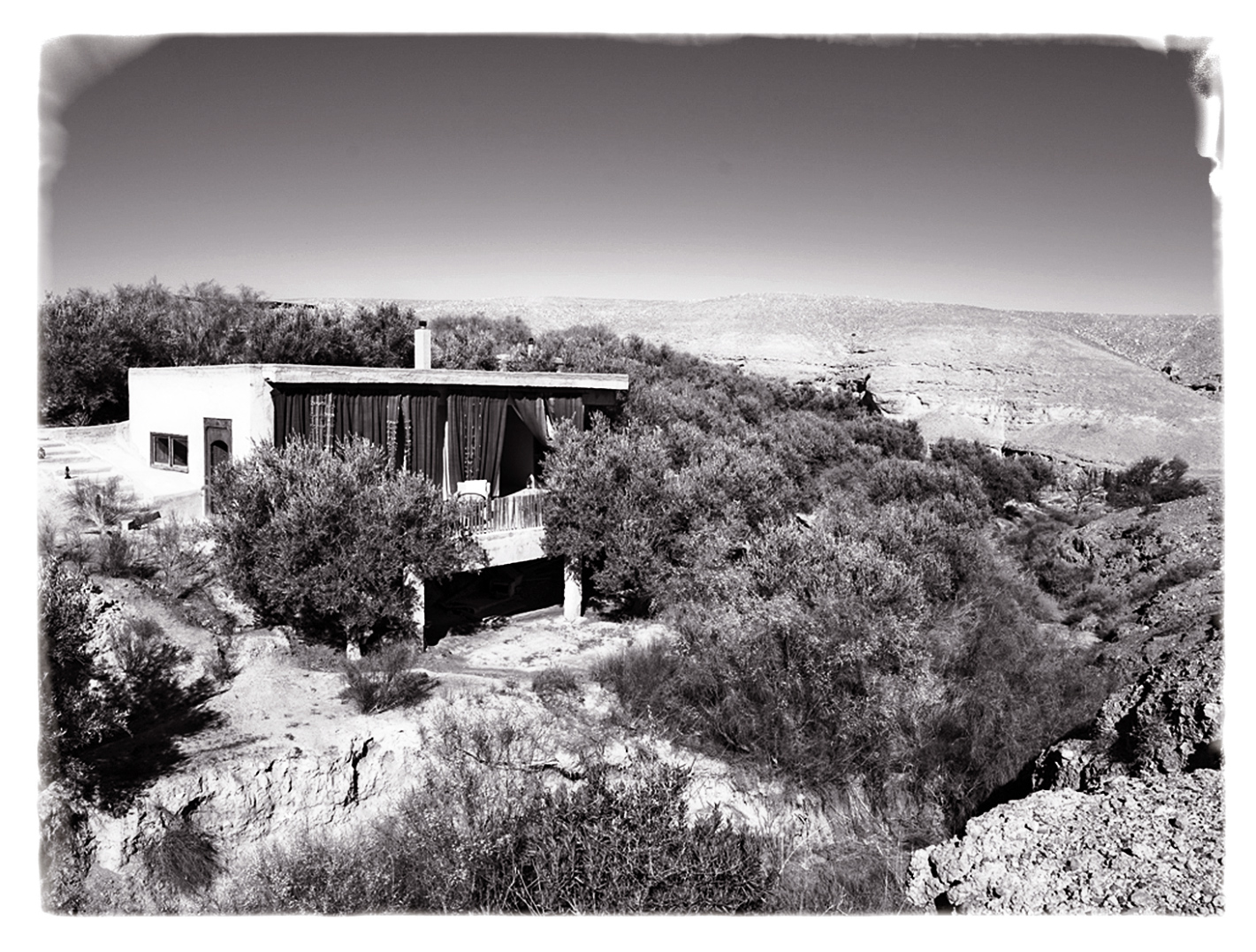 Photo en noir et blanc de l'un des lodges entouré par la nature à La Pause, Maroc